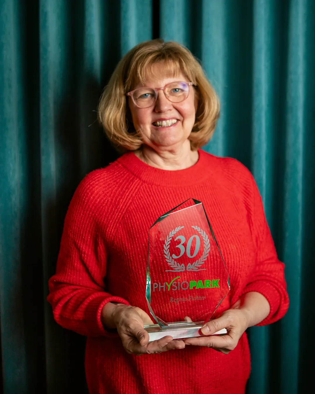 Regina Fichter hält einen Pokal mit der Aufschrift 30 Jahre
